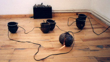 1996 -  RILKE W VALAIS, CRP Orońsko; 12 kokili żeliwnych, żarówka, metalowa smołowana skrzynia, kamienie; ok. 200 x 200cm